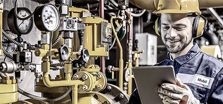 Mobil worker looking at an iPad next to a heat pump