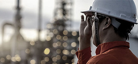 Mobil worker looking over a large factory