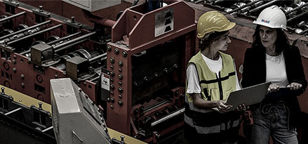 Mobil worker and customer looking at an iPad in a factory