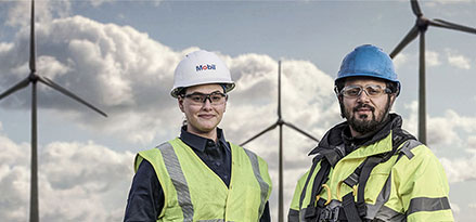 Mobil worker and customer in front on wind turbines