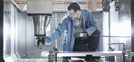 Mobil worker moving electronic drill above sheet of plastic