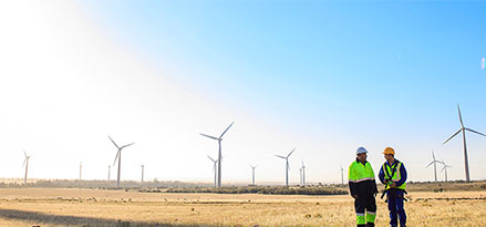 Two Mobil engineers standing in the middle of a wind farm