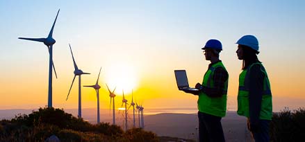 workers stood next to wind turbines